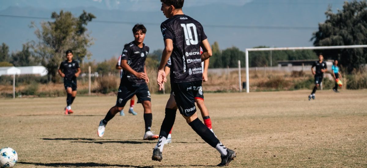 Teen soccer game in a sunny field with stunning mountain views in the background.
