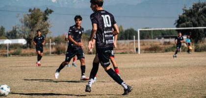Teen soccer game in a sunny field with stunning mountain views in the background.