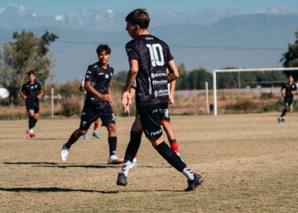 Teen soccer game in a sunny field with stunning mountain views in the background.